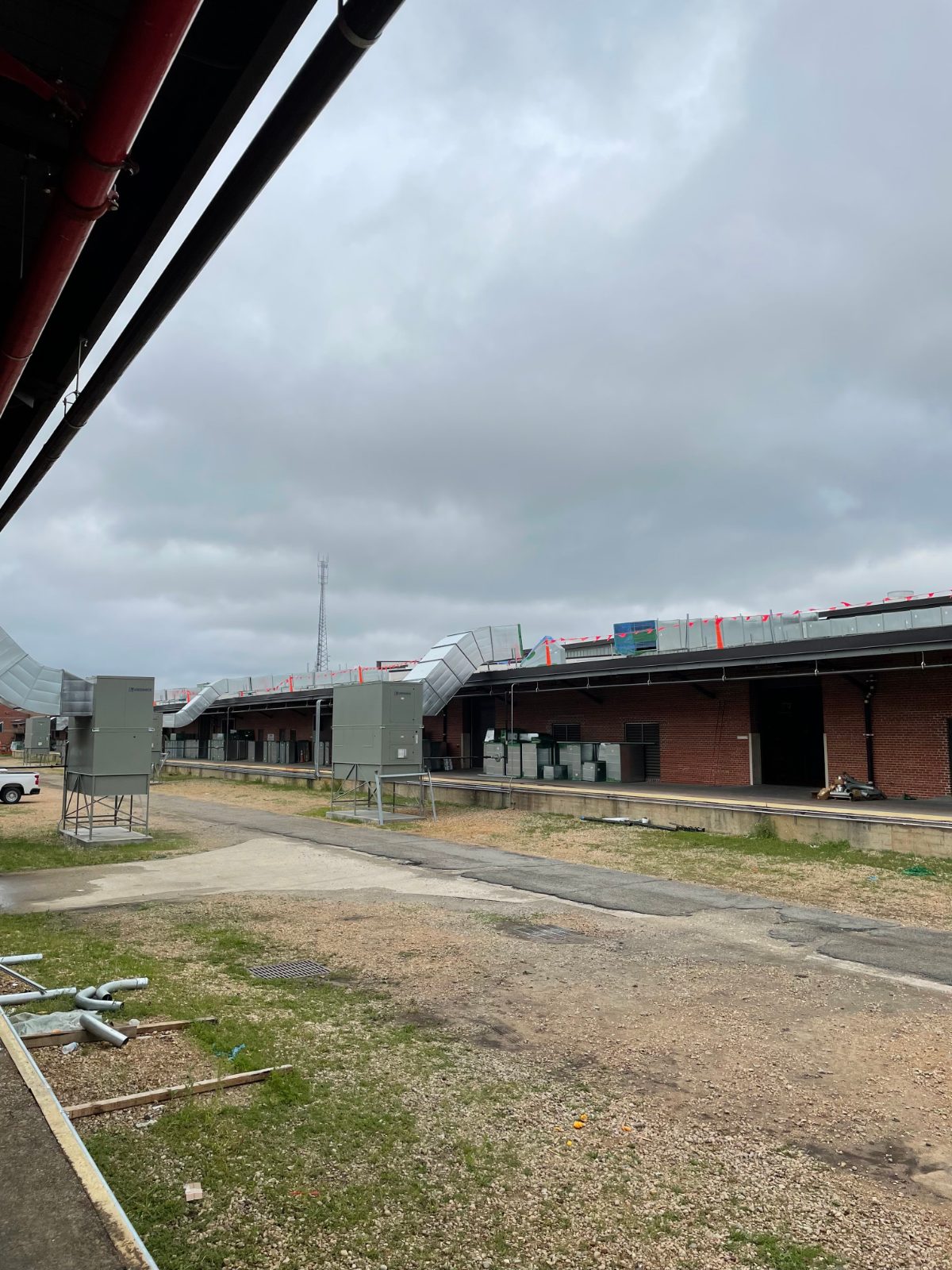 Rooftop duct run and rooftop units along a long brick building