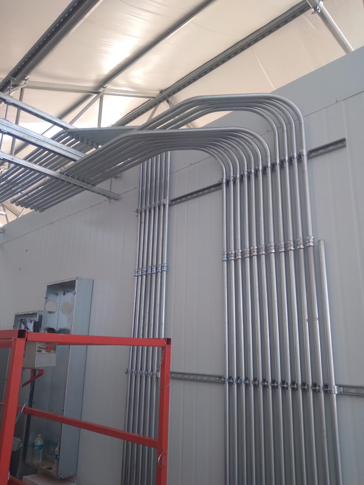 A bank of matched conduit 90s sweeping across a wall into gear